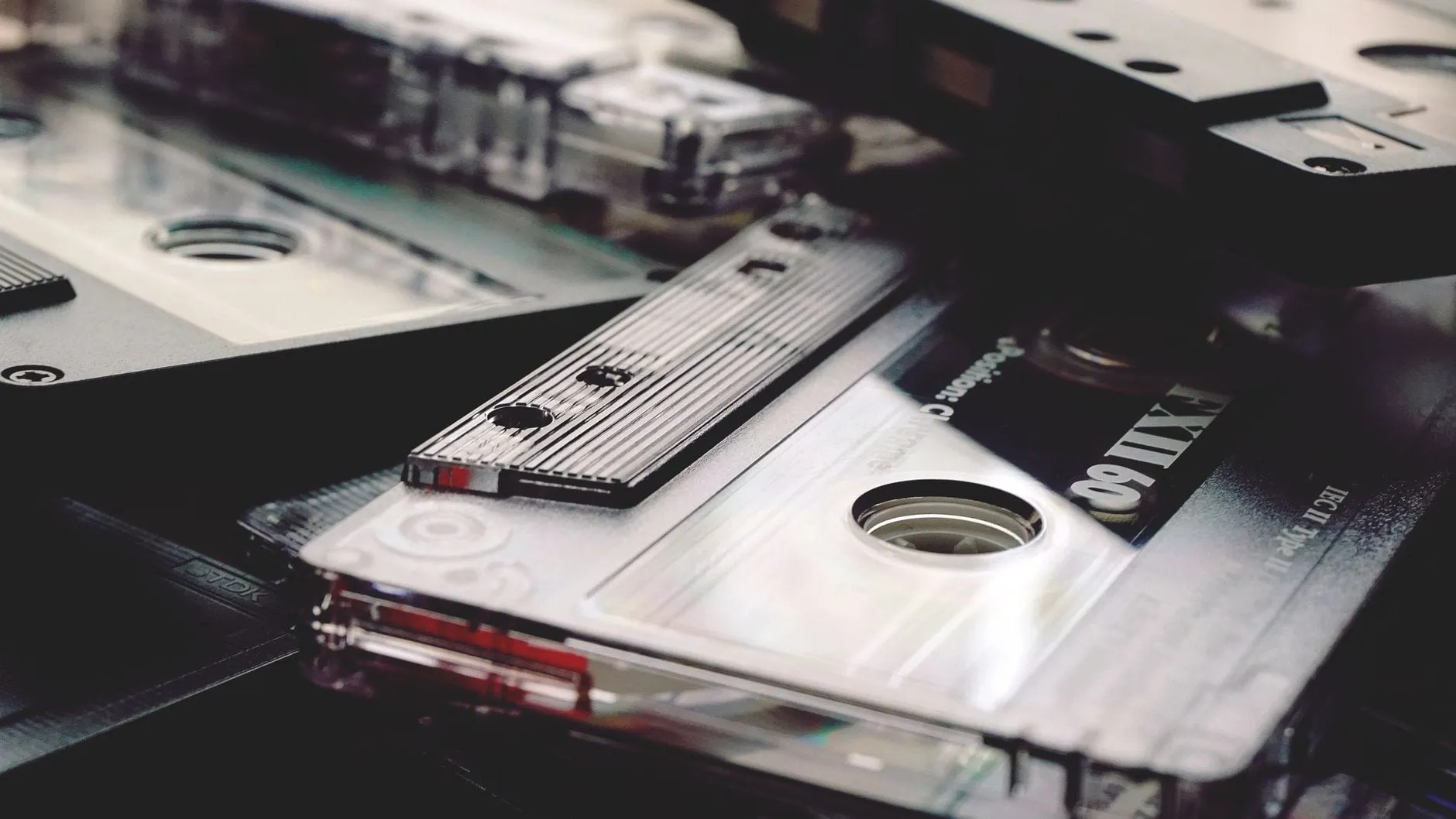 Blank cassette shells overlapping in close-up, their spec markings reading Position: chrome and IEC II Type II.